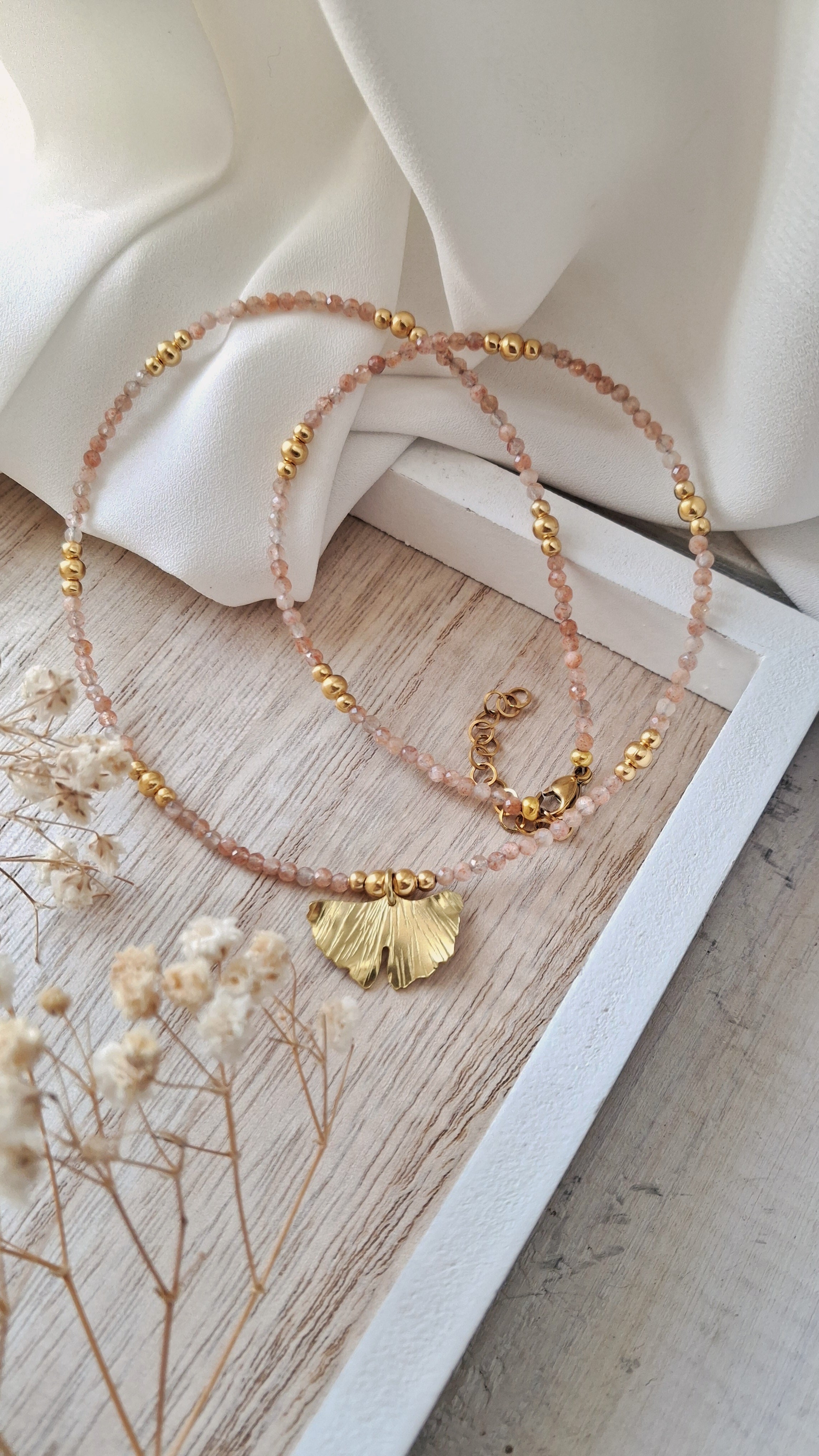 collana girocollo con cavetto di acciaio, pietra di luna rosa e ciondolo a foglia di ginkgo biloba in ottone