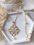 collana lunga in acciaio e perle di fiume, con ciondolo arabescato in ottone, fatta a mano
